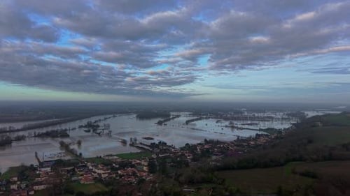 Aerial view of flooded vineyards reflecting the morning sky, with trees emerging from the water