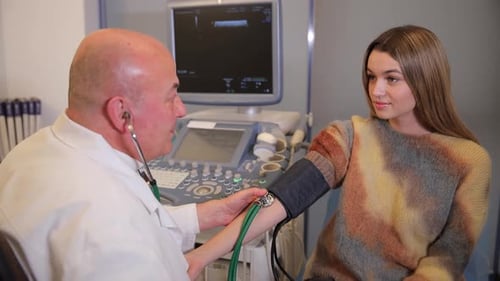 Doctor Checks Patient's Blood Pressure in Clinic