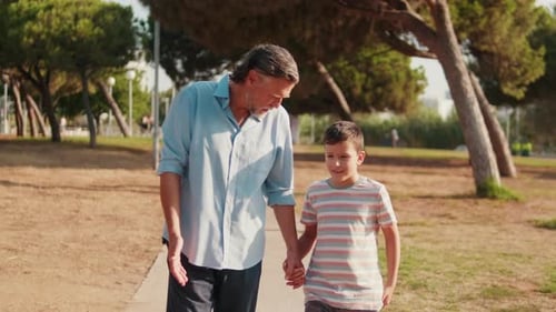 Grandfather and Grandson Walking in the Park