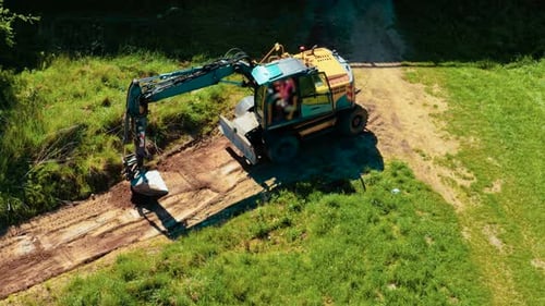 Excavator Digging Along Rural Path from Aerial View