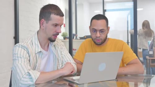 Multiethnische junge Menschen diskutieren über Arbeit am Laptop