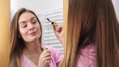 Woman Applying Eye Mascara To Her Eyelashes