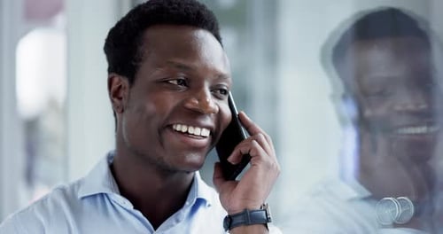 Young Man Talking on Phone Smiling in Office