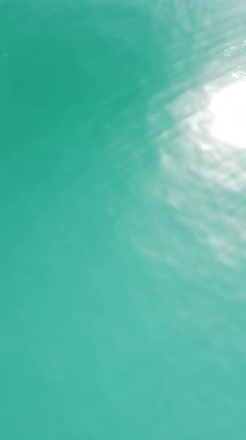 Vertical Aerial View on Sea Water Surface Camera Flies Over Clear Sea Water Sun Glare Abstract