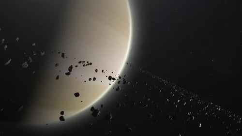 Plan Cinématographique de Saturne et d'astéroïdes ou de roches en orbite autour d'un anneau. Une planète immense dans un espace sombre et étoilé.