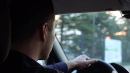 Junger Mann in Autofahrerin fährt vorsichtig Ernster konzentrierter Kerl hält Hände am Lenkrad