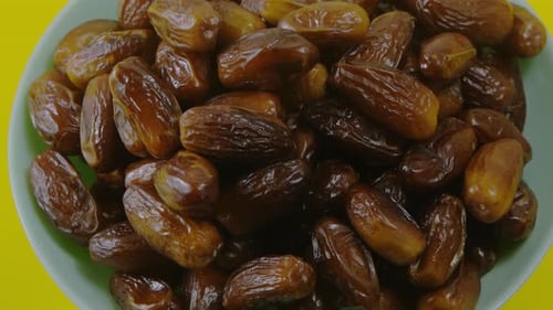 Bowl of Fresh Dates on Yellow Background
