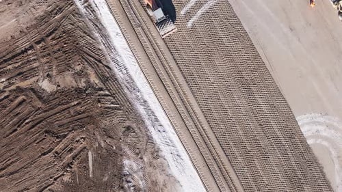 Construction with a bulldozer. View from above. A yellow bulldozer falls to the ground with a bucket