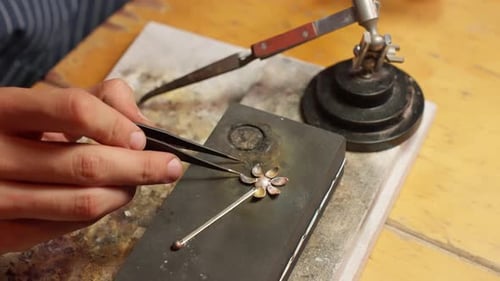 Herstellung eines silbernen Blumenanhängers mit Metallbearbeitungswerkzeugen in einer Werkstatt
