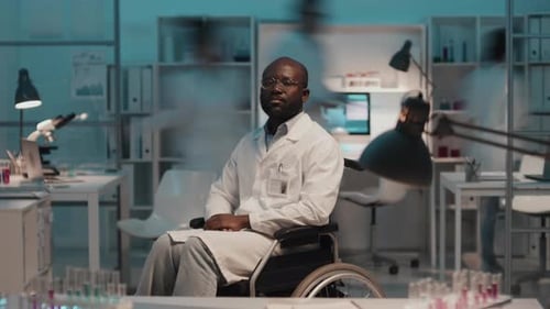 Scientist in Wheelchair Sits in Busy Lab