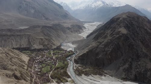Aerial View of a Serene Village Nestled in the Mountains of Pakistan Surrounded By Majestic