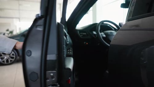 Close Up of a Female Hand Opening a New Car Door in Car Dealership