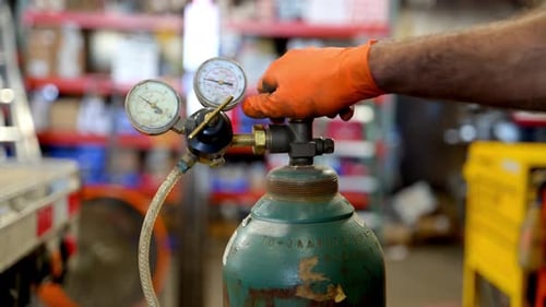Gloved Hand Adjusts Gas Tank Valve