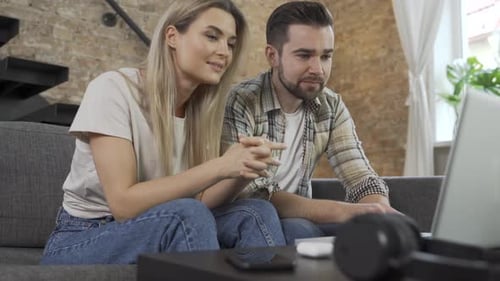 Couple Using Laptop Together on a Sofa