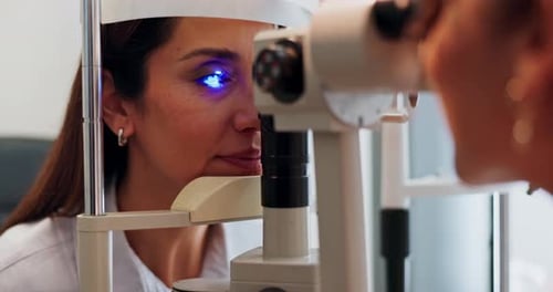Frau, Augenuntersuchung und Test mit Licht am Gerät zur Seh-, Seh- oder Optometriebehandlung