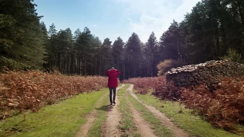 Man with Red Jacket Walking in Mountain Street