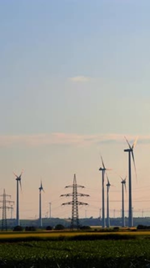 Renewable energy from wind. Wind turbines stand tall against a clear sky
