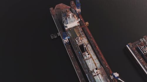 Aerial View of Shipyard with Cranes and Vessel at Sunset in Riga
