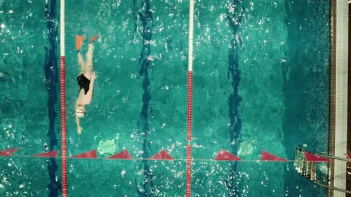 Nadador en movimiento en el carril de la piscina cubierta desde arriba