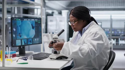 Pesquisadora negra estuda amostras de biologia molecular em um laboratório