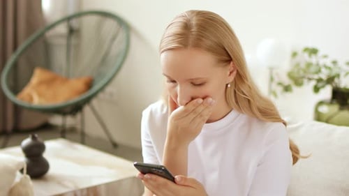 Young Woman Using Smartphone with Disappointed Reaction Indoors