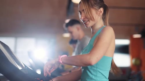 Attractive Young Woman on Treadmill Use Smartwatch in Gym Sportsman Sport Fitness Internet Face
