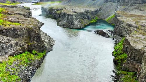 Spektakulärer Canyon mit scharfen Klippen und starkem Fluss in Nordisland Epische Luftaufnahme von Dramatisch