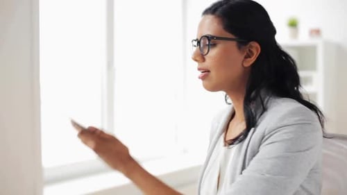 Smiling woman talking on her phone in office