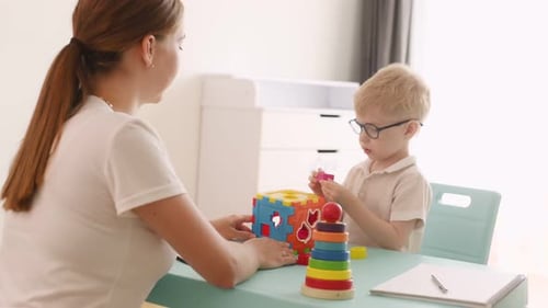 Compone acertijos de lógica. El logopeda está con un niño pequeño en el interior.