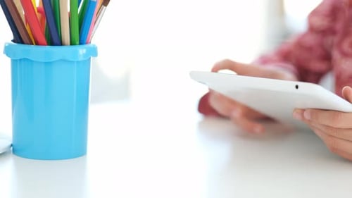 Child Using Tablet at White Table