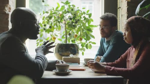 Diverse Colleagues Talking over Coffee in Cafe
