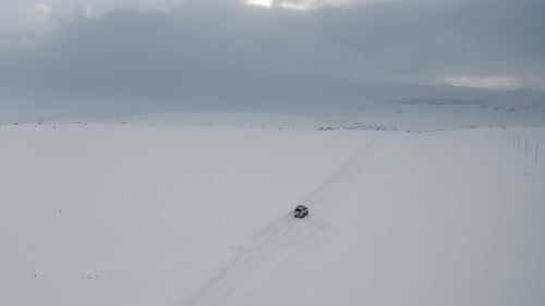Aerial view driving car on snow. Winter time off road car on white road.