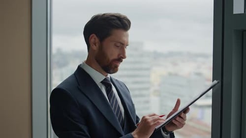 Satisfied businessman analyzing contract terms at office window feeling successful