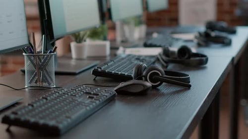Empty call center office with computers and audio headsets used to have conversation with people
