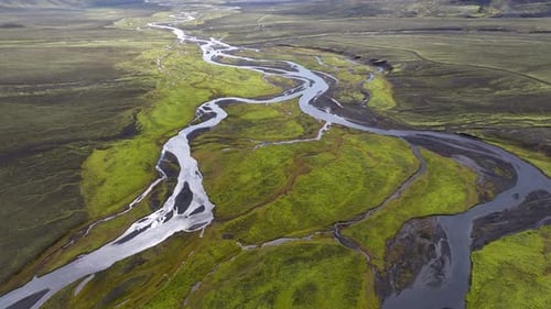 Aerial view of winding river in lush valley, Iceland.