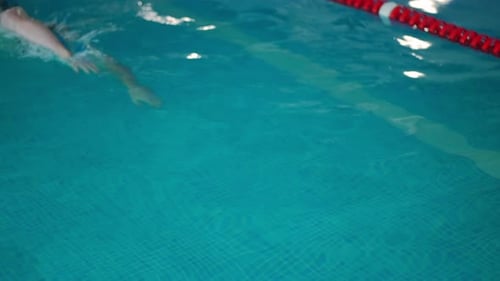 Top View Swimming Pool Track with Young Caucasian Swimmer Passing in Slow Motion