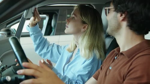 Couple Sitting In Car In Dealership Showroom