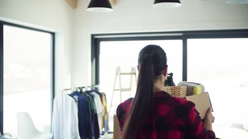 Woman Moving into New Home with Moving Box