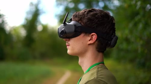 A Young Man Pilots A Drone And A Remote Controlled Vehicle With An Augmented Virtual Reality Headset
