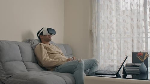 Man Using Virtual Reality Headset Relaxing on Couch