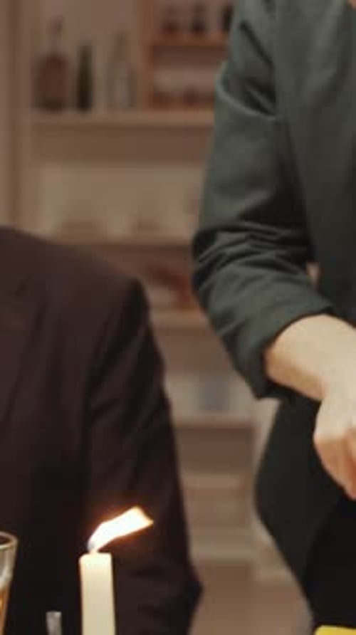 Male Party Host Cutting Roasted Meat and Putting It on Friends Plate
