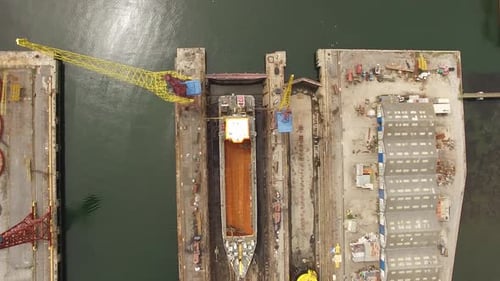 Riesiges Trockendock der Industriewerft mit Blick auf die ruhigen Küstenhafengewässer