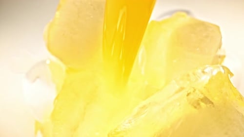 Orange Liquid Poured Over Ice Cubes