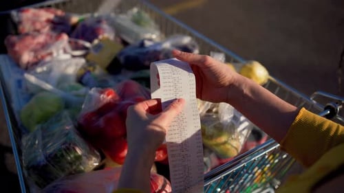 Woman Checks Paper Check After Shopping for Groceries at Mall By Checking Dear Amount Bill in a