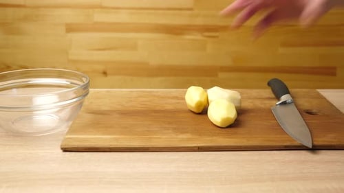 01sm. Place peeled potatoes and carrots on a cutting board. Preparation of a vegetable dish. Slow mo