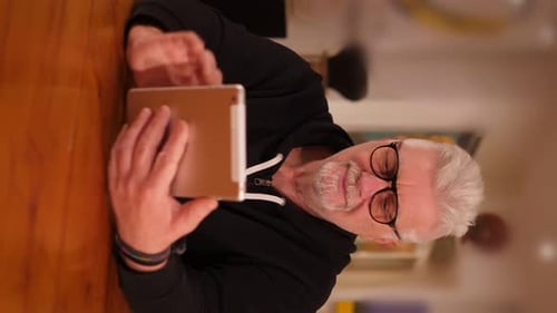 Man With Gray Hair Uses Tablet Indoors