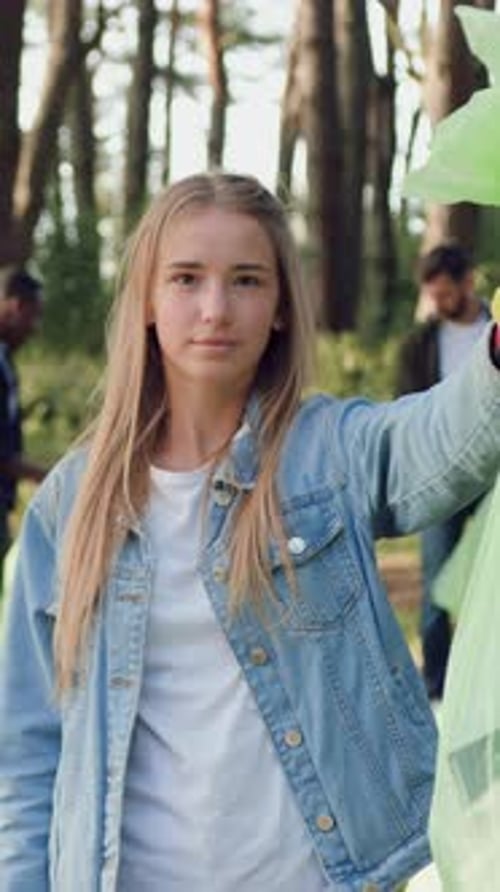 Teen Volunteer Holding Trash Bag Gives Thumbs Down