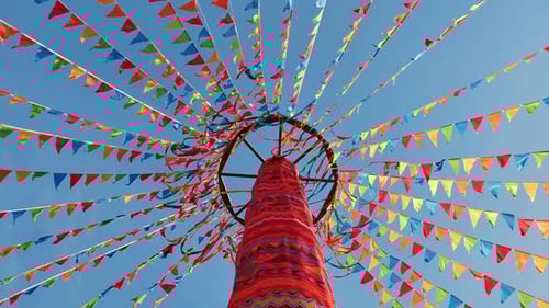 Upward View of Celebration Flags Against Blue Sky