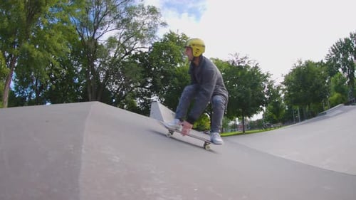 Slow motion skateboarder fast plant over a bank to bank hip jump