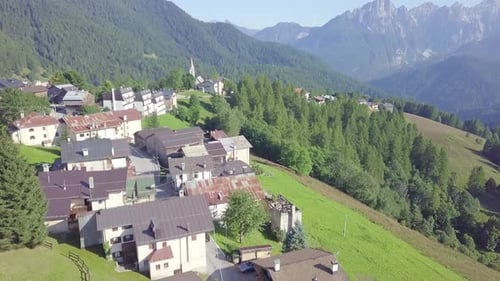 Drone over mountain village and pine trees